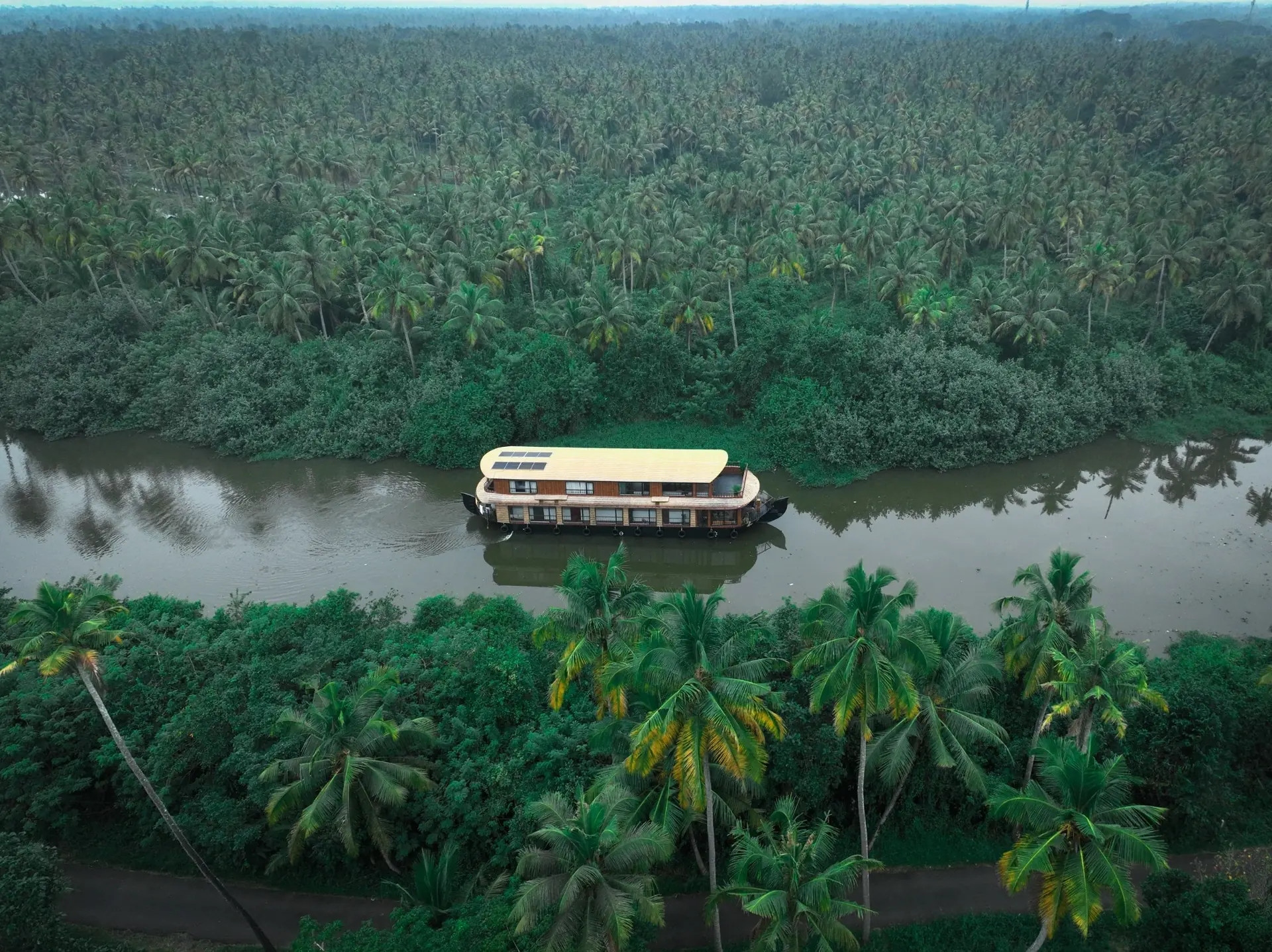 Aerial view of a luxury houseboat cruising through the Alleppey backwaters