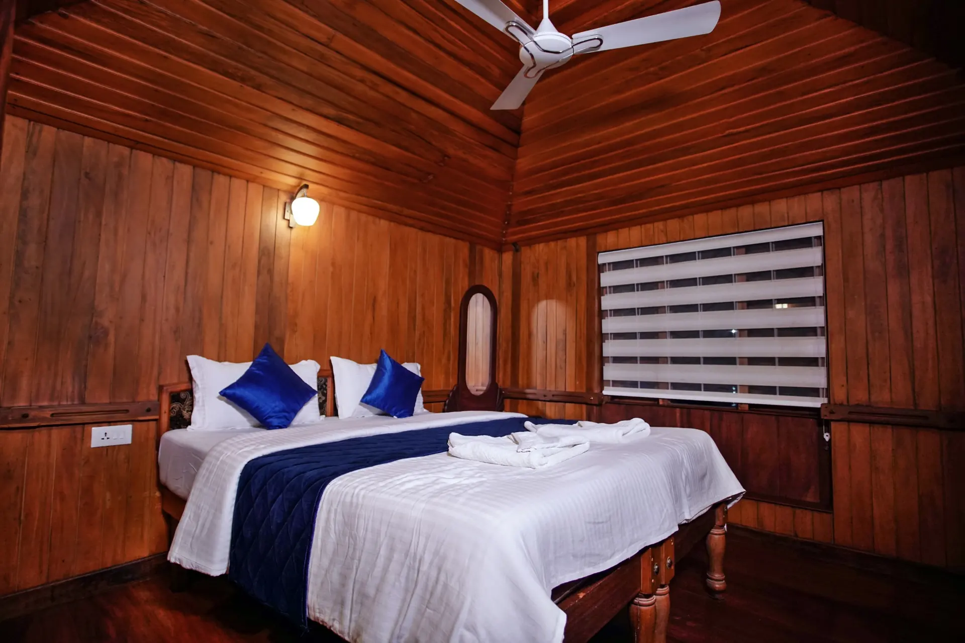 Deluxe Kerala houseboat bedroom with warm wooden interiors
