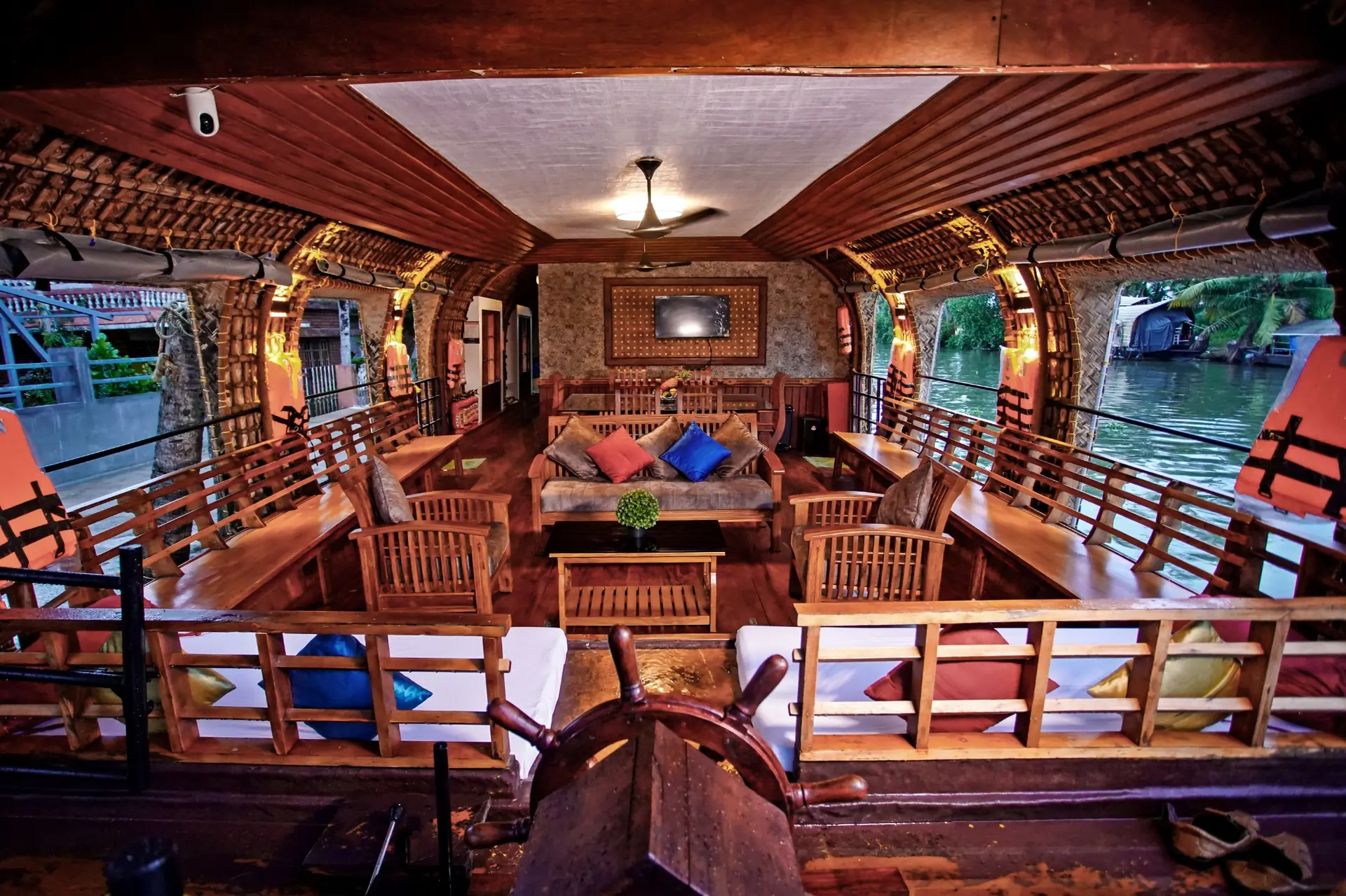 Premium Kerala houseboat lounge deck with warm wooden interiors