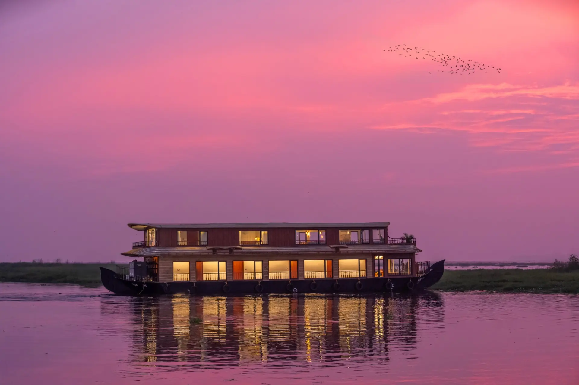 Luxury houseboat on Vembanad Lake at pink sunset